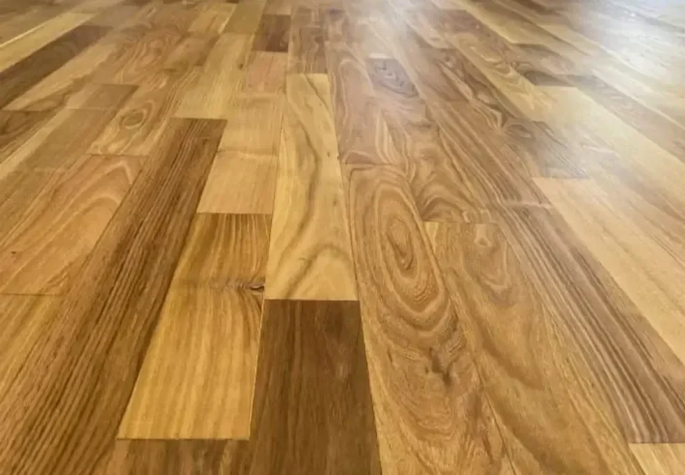Professionally polished multi-toned hardwood flooring in a Calgary home, showcasing a high-quality satin finish on natural oak and maple planks to enhance wood grain and durability